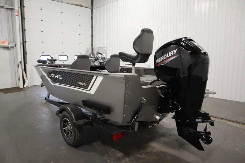 Slide: The Image of 2026 Lowe Fishing Machine 1625SC boat in a garage, featuring dual seats and trolling motor. - 6