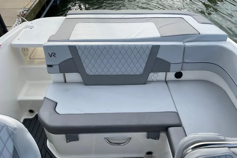 Slide: The Image of 2023 Bayliner VR5 boat interior with gray cushioned seating and quilted design. - 18
