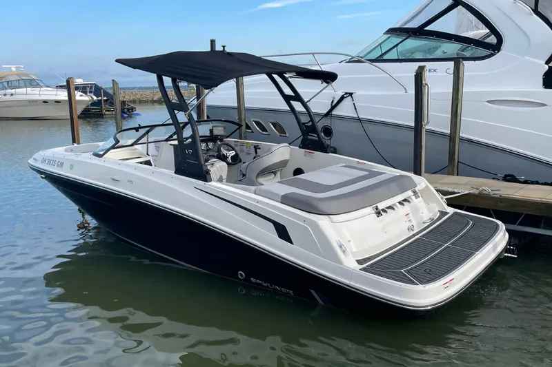 Slide: The Image of 2023 Bayliner VR5 boat docked, featuring sleek design and spacious seating. - 2