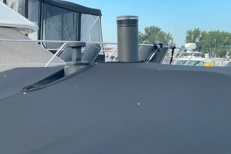 Slide: The Image of 2023 Bayliner VR5 boat with black cover, docked near other boats. - 24