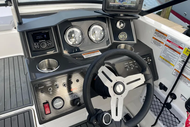 Slide: The Image of 2023 Bayliner VR5 boat dashboard with steering wheel and navigation controls. - 6
