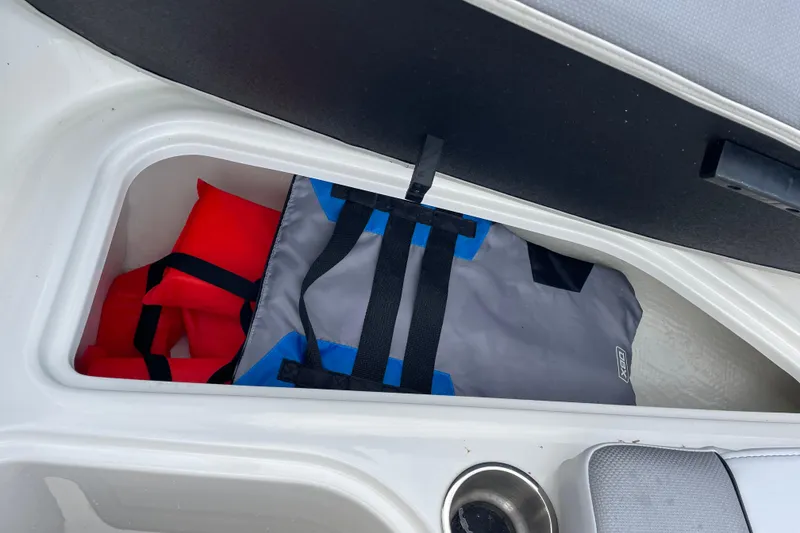 Slide: The Image of 2023 Bayliner VR5 boat storage compartment with life jackets and gear bag. - 9