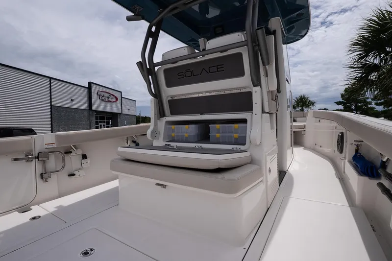 Slide: The Image of 2026 Solace 30 CS boat interior with seating and storage, docked near a building. - 11
