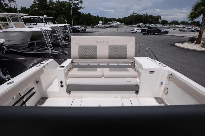 Slide: The Image of 2026 Solace 30 CS boat interior with cushioned seating in a marina setting. - 14