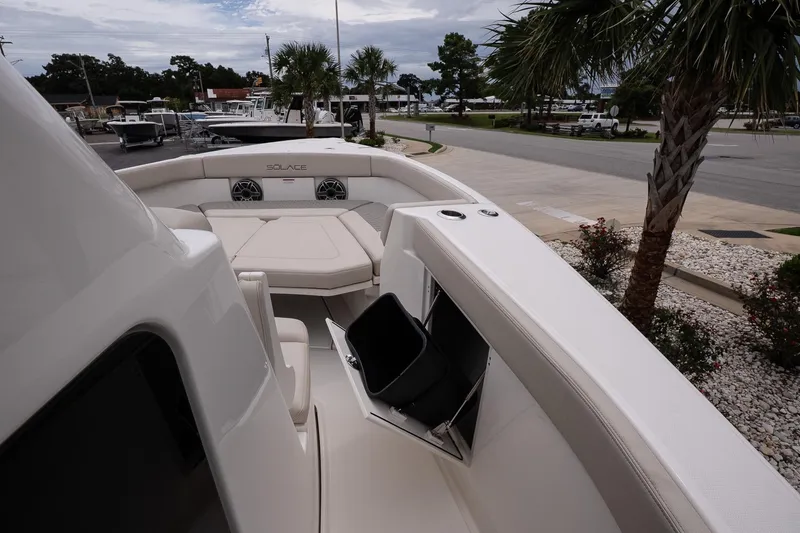 Slide: The Image of 2026 Solace 30 CS boat with spacious seating and sleek design, docked near palm trees. - 32