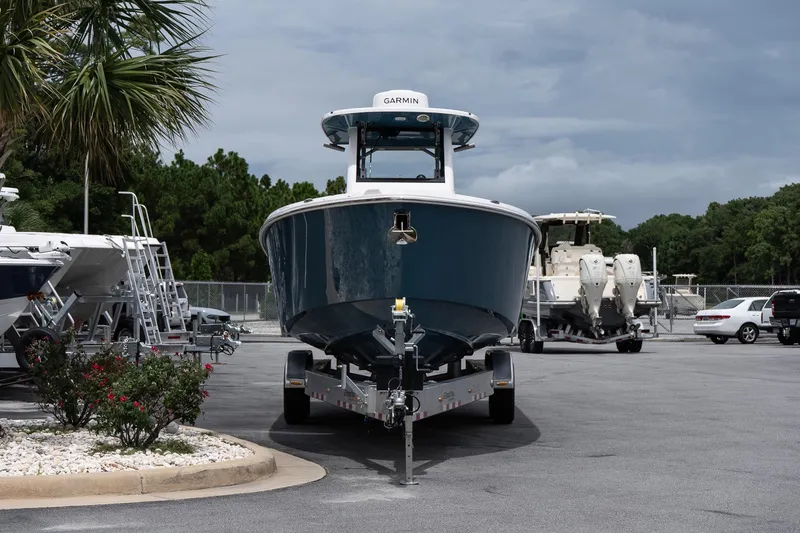 Slide: The Image of 2026 Solace 30 CS boat on trailer in parking lot, surrounded by trees and vehicles. - 4