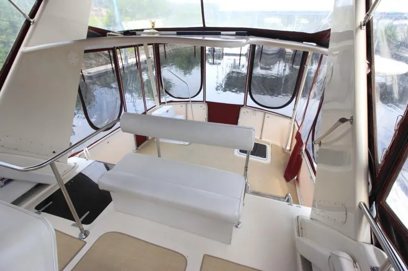 Slide: The Image of 1990 Silverton 40 Aft Cabin interior with white seating and panoramic windows. - 10