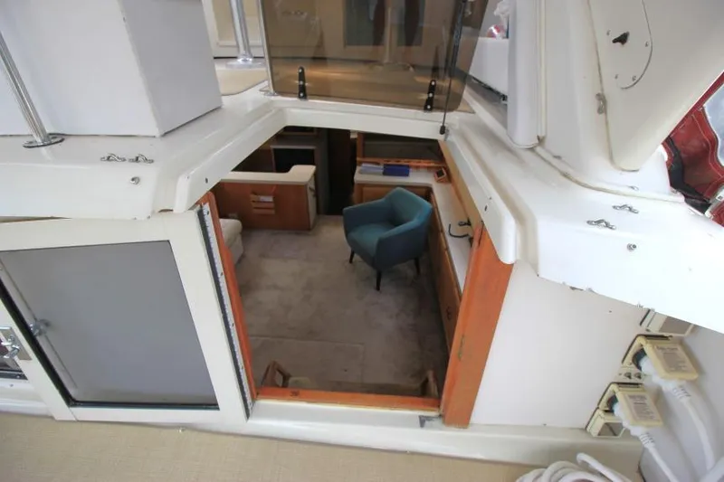 Slide: The Image of 1990 Silverton 40 Aft Cabin interior view with blue chair and wooden accents. - 15
