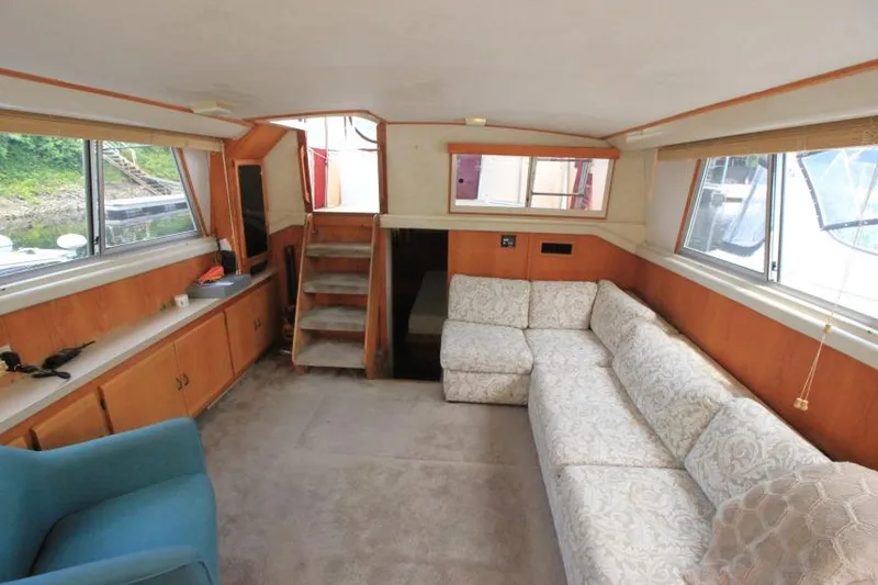 Slide: The Image of Interior of 1990 Silverton 40 Aft Cabin with beige sofa and blue chair. - 19
