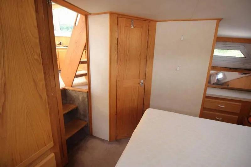 Slide: The Image of 1990 Silverton 40 Aft Cabin interior with wooden cabinetry and stairs. - 25