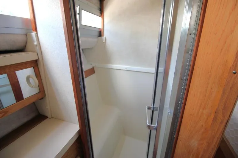 Slide: The Image of Shower area in 1990 Silverton 40 Aft Cabin yacht, featuring wood accents and glass door. - 27