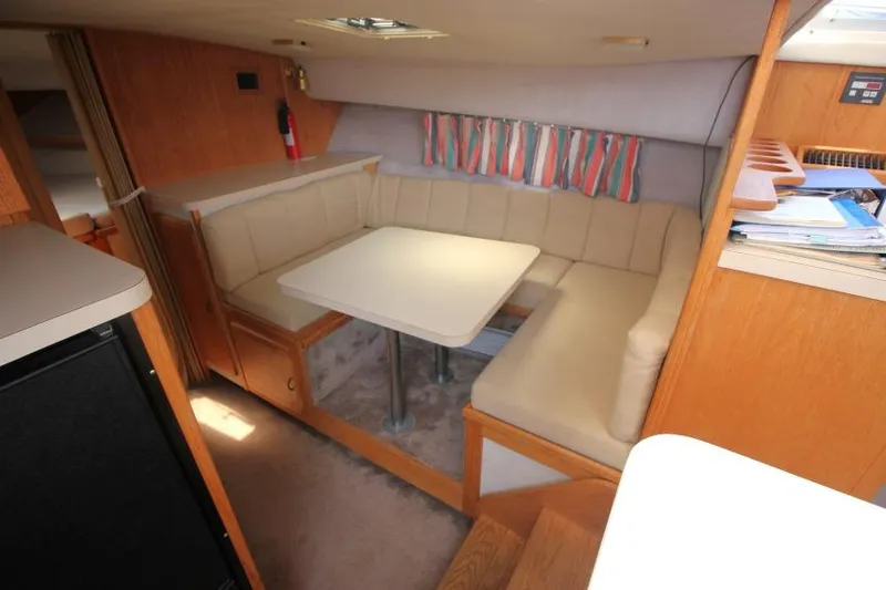 Slide: The Image of 1990 Silverton 40 Aft Cabin interior with cozy dining area and beige seating. - 28