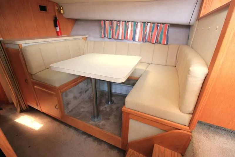 Slide: The Image of 1990 Silverton 40 Aft Cabin interior with cozy dining area and colorful curtains. - 29