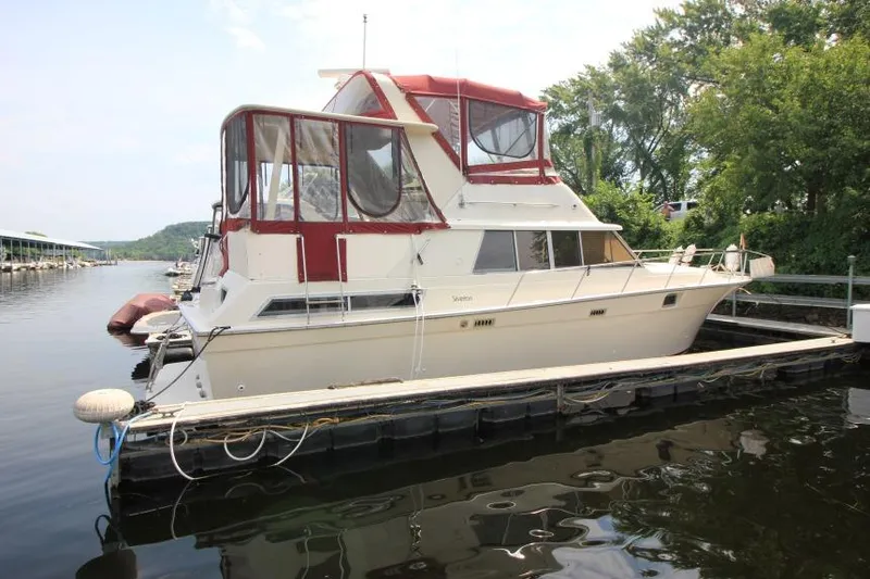 Slide: The Image of 1990 Silverton 40 Aft Cabin yacht docked at marina, featuring red canopy and white hull. - 3