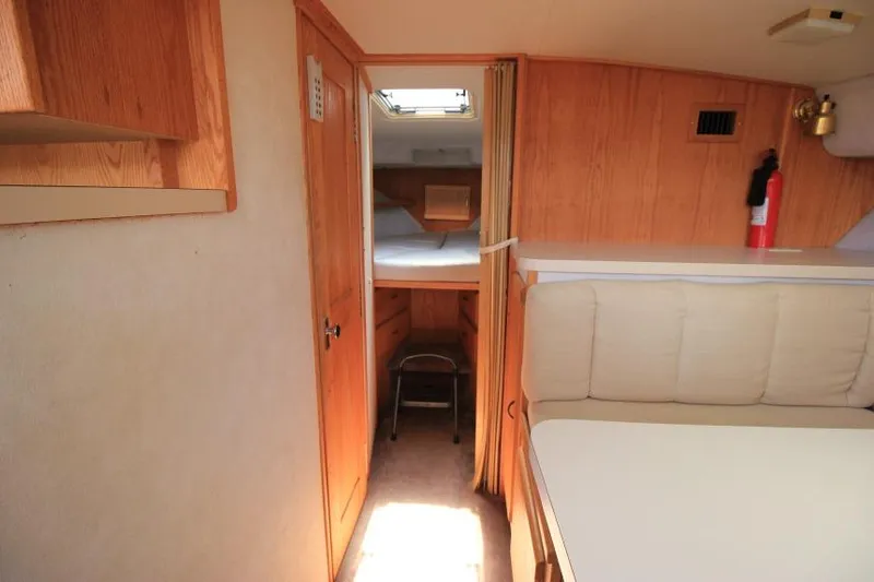 Slide: The Image of 1990 Silverton 40 Aft Cabin interior with wood paneling and cozy seating area. - 31