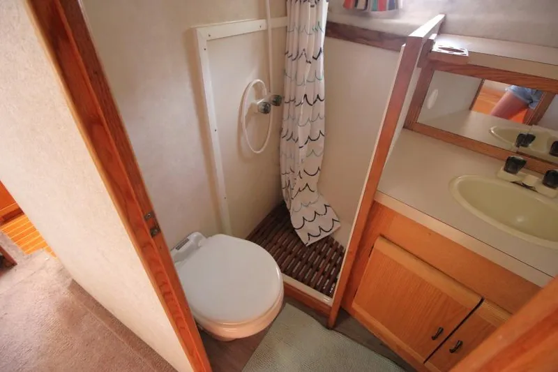 Slide: The Image of Bathroom in 1990 Silverton 40 Aft Cabin yacht, featuring shower, toilet, and sink. - 32