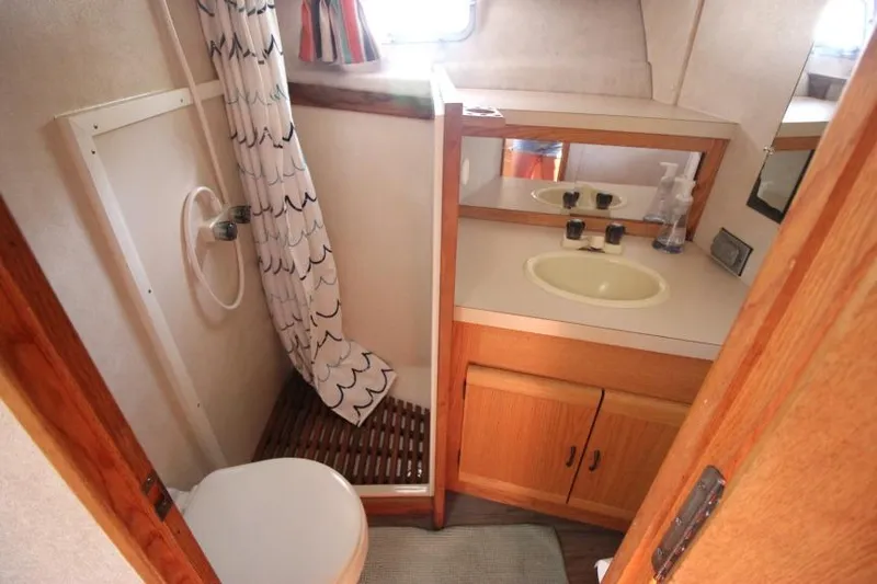 Slide: The Image of 1990 Silverton 40 Aft Cabin bathroom with shower, sink, and wooden cabinetry. - 33