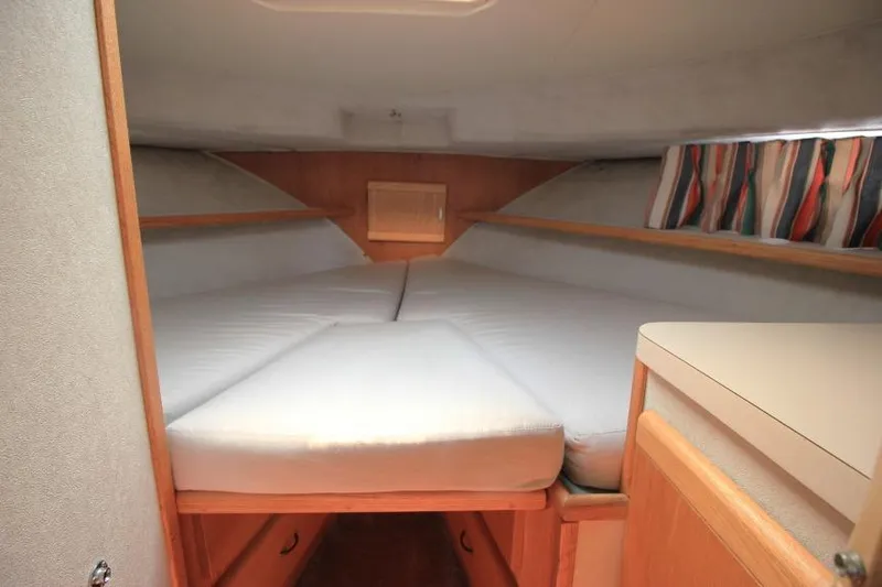 Slide: The Image of 1990 Silverton 40 Aft Cabin interior with cozy V-berth and colorful curtains. - 35