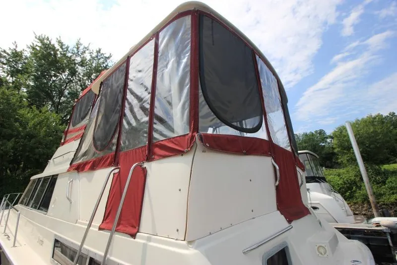 Slide: The Image of 1990 Silverton 40 Aft Cabin boat with red canvas enclosure, docked outdoors. - 5