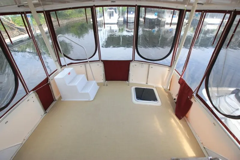 Slide: The Image of 1990 Silverton 40 Aft Cabin interior with panoramic windows and steps, docked at marina. - 6