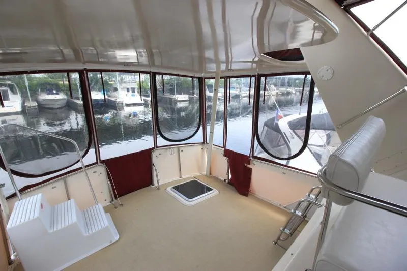 Slide: The Image of 1990 Silverton 40 Aft Cabin interior with marina view through large windows. - 8