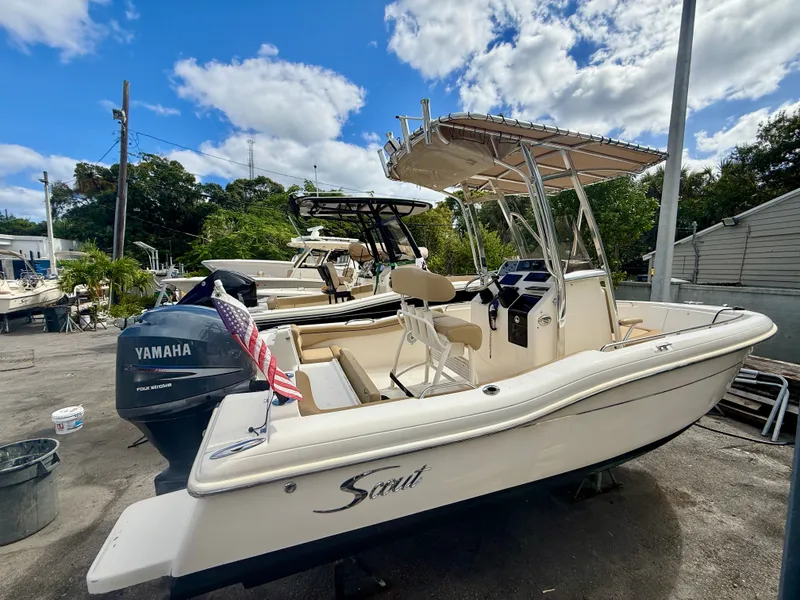 The Image of 2012 Scout 210 XSF boat with Yamaha engine, docked outdoors under a blue sky. - 0