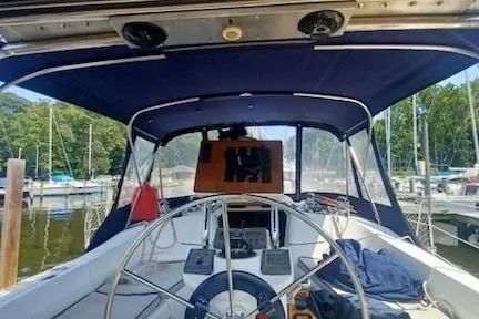 Slide: The Image of 2003 Hunter 356 sailboat cockpit with steering wheel, docked at marina. - 2