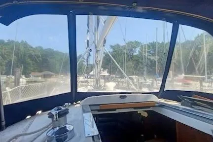 Slide: The Image of Interior view of 2003 Hunter 356 sailboat cockpit with marina backdrop. - 6