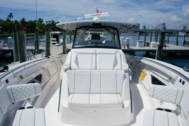 Slide: The Image of 2022 Pursuit S 428 Sport boat with luxurious seating at a marina. - 10