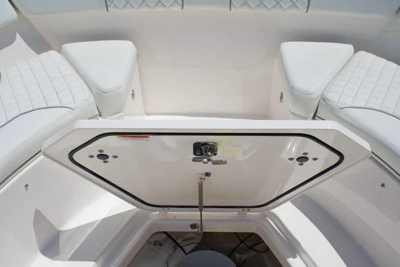 Slide: The Image of 2022 Pursuit S 428 Sport boat interior with open storage compartment and cushioned seating. - 15