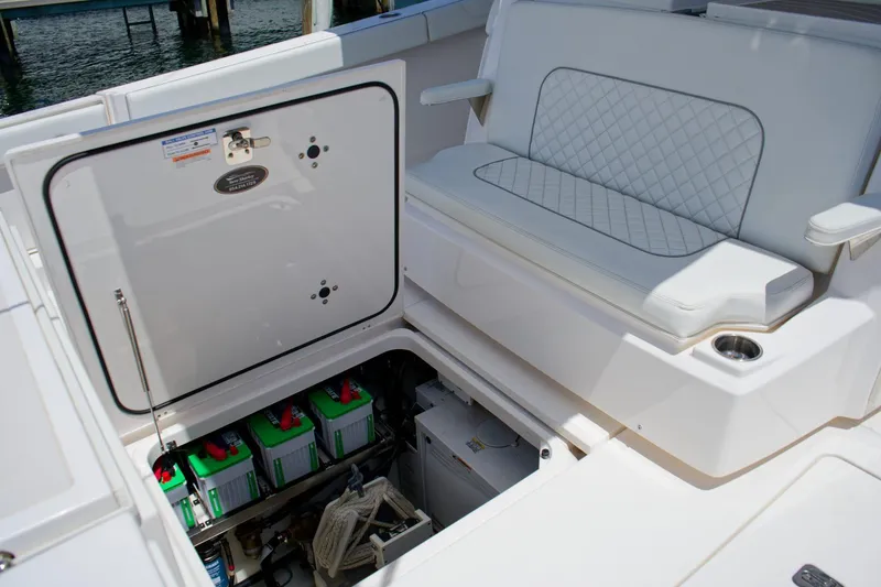 Slide: The Image of 2022 Pursuit S 428 Sport boat interior with battery compartment and cushioned seating. - 16