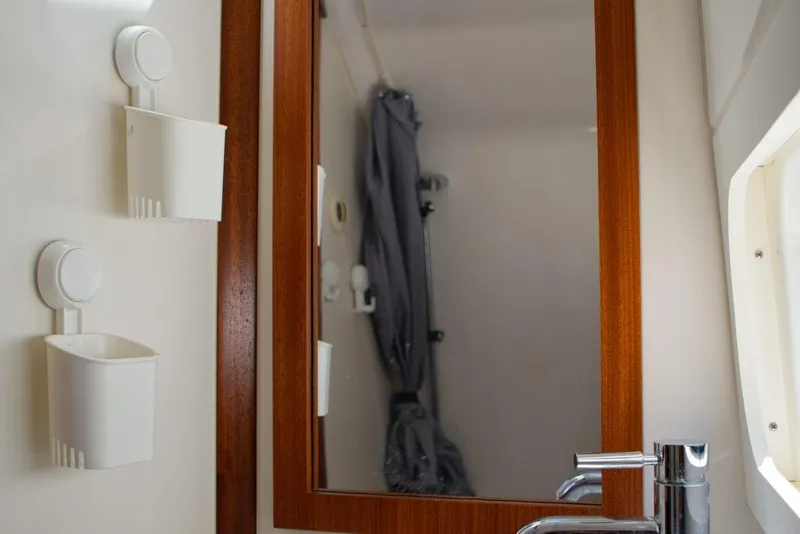 Slide: The Image of Bathroom interior of 2022 Pursuit S 428 Sport boat with mirror and storage. - 19