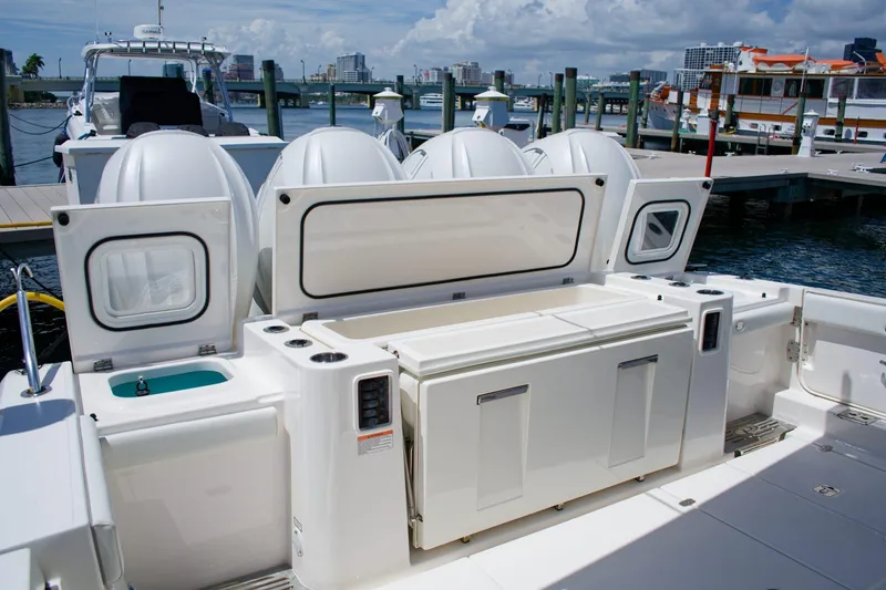 Slide: The Image of 2022 Pursuit S 428 Sport boat at dock with open storage compartments. - 23