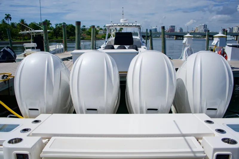 Slide: The Image of 2022 Pursuit S 428 Sport boat with four powerful outboard engines docked at marina. - 8