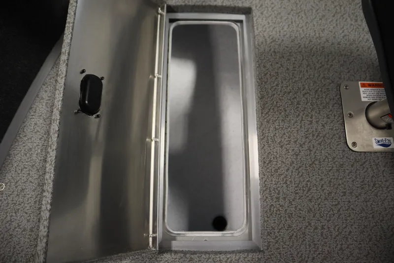 Slide: The Image of 2026 Lowe Fishing Machine 1675SC storage compartment with carpeted interior and Swivl-Eze mount. - 17