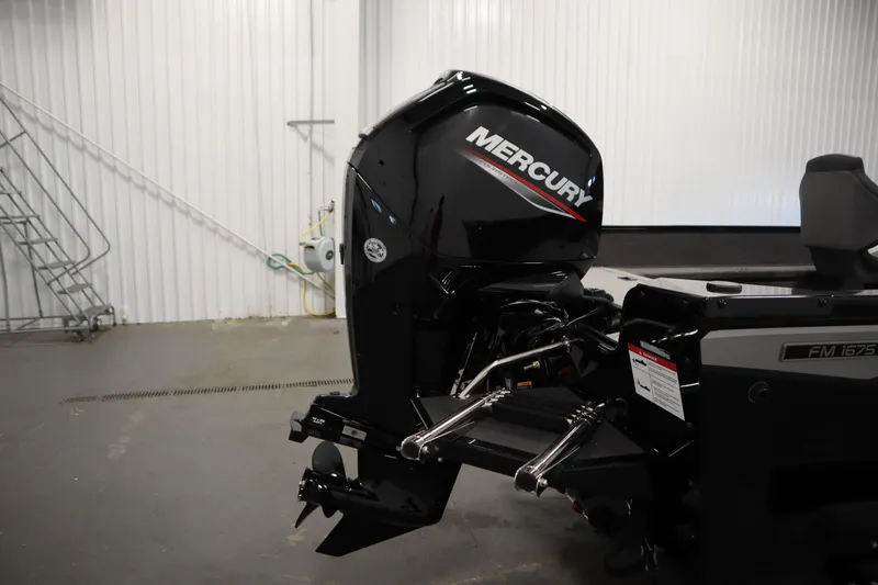 Slide: The Image of 2026 Lowe Fishing Machine 1675SC with Mercury outboard motor in a garage setting. - 38