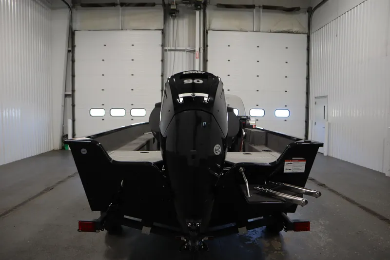 Slide: The Image of 2026 Lowe Fishing Machine 1675SC in a garage, rear view with Mercury engine. - 5