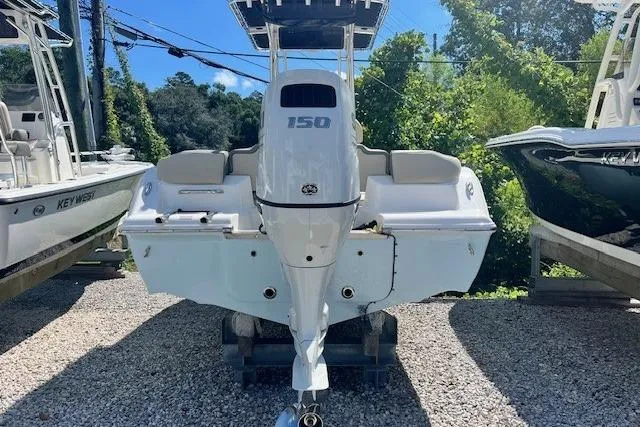 Slide: The Image of 2025 Key West 203 FS boat, rear view, parked outdoors on gravel. - 3