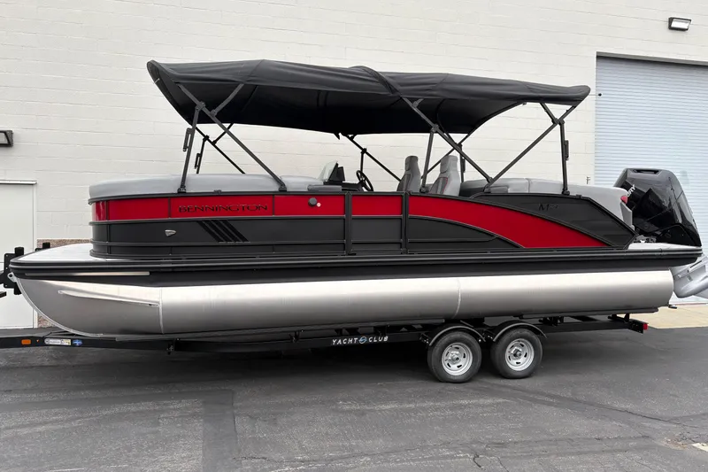 The Image of 2026 Bennington 24 MFB pontoon boat with red and black design on a trailer. - 0