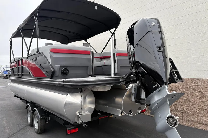 Slide: The Image of 2026 Bennington 24 MFB pontoon boat with outboard motor and canopy, parked on trailer. - 3