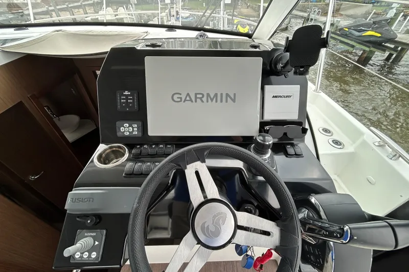 Slide: The Image of 2024 Beneteau Antares 11 helm with Garmin navigation and Mercury controls. - 14