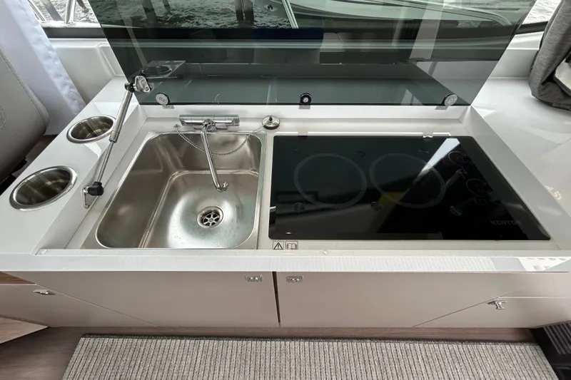 Slide: The Image of 2024 Beneteau Antares 11 kitchen with sink and electric stove. - 18