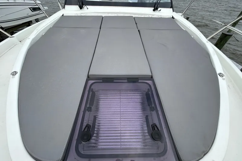 Slide: The Image of 2024 Beneteau Antares 11 boat deck with cushioned seating and hatch. - 2