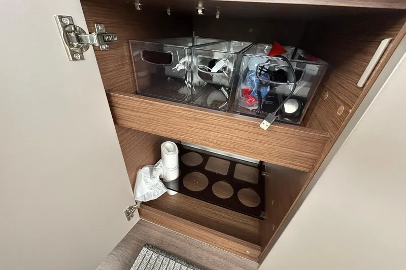 Slide: The Image of Storage cabinet in 2024 Beneteau Antares 11 with organized compartments and accessories. - 20