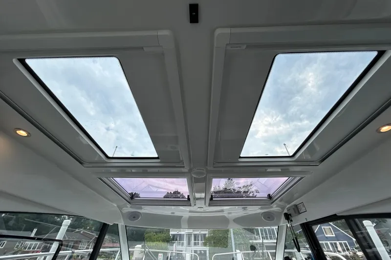 Slide: The Image of 2024 Beneteau Antares 11 interior skylights with scenic sky view. - 21