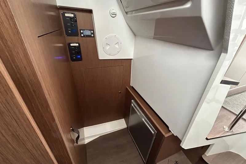 Slide: The Image of 2024 Beneteau Antares 11 interior with control panels and wood finish. - 22