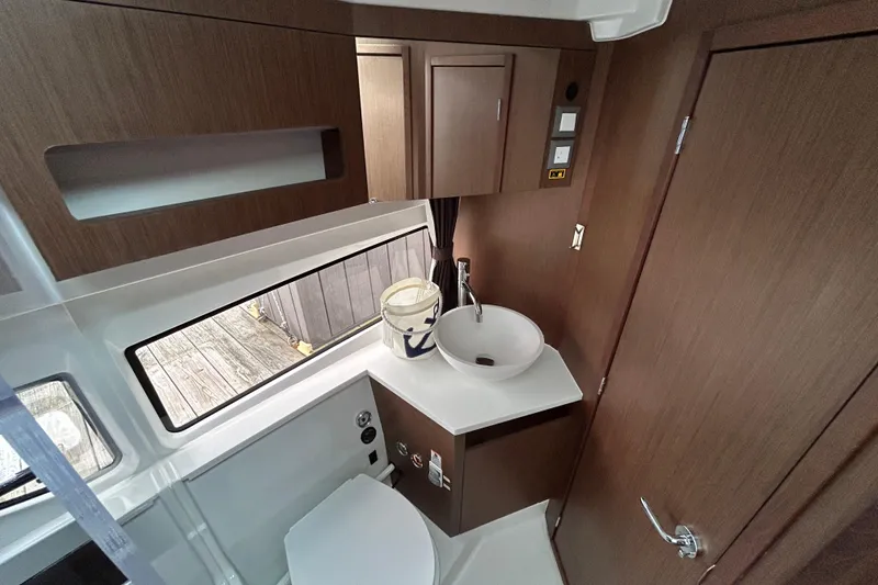 Slide: The Image of 2024 Beneteau Antares 11 bathroom with modern sink, wooden cabinetry, and window view. - 26