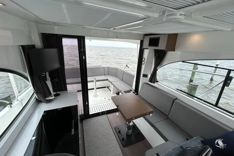 Slide: The Image of 2024 Beneteau Antares 11 interior with modern seating and ocean view. - 27