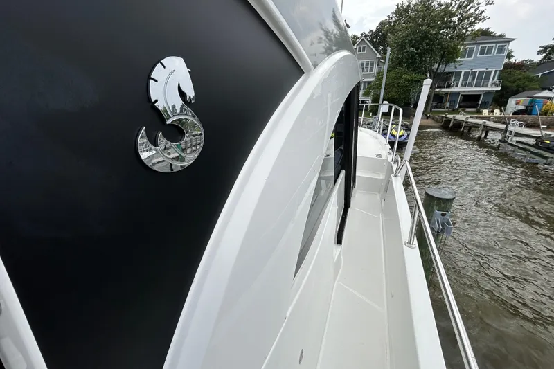 Slide: The Image of 2024 Beneteau Antares 11 boat docked by waterfront homes. - 4