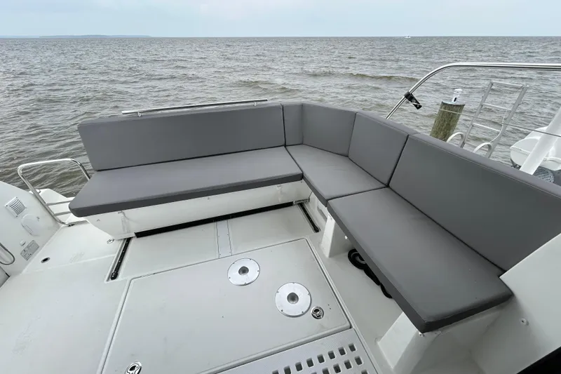 Slide: The Image of 2024 Beneteau Antares 11 boat deck with gray seating, overlooking the ocean. - 6